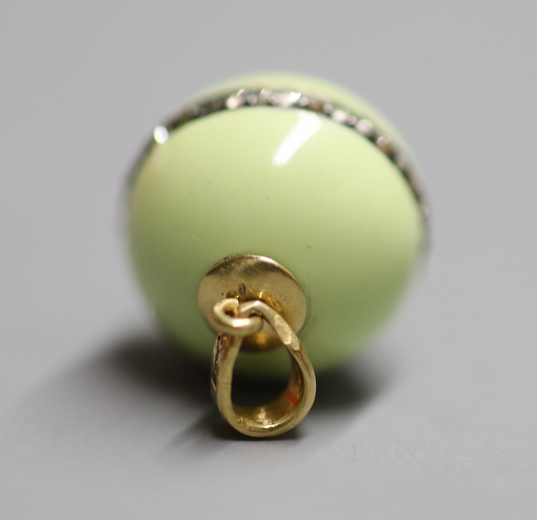 An 18ct, pale green enamel and rose cut diamond set globular pendant, 15mm, gross weight 4.4 grams.